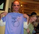 Rozalina Gutman presenting T-shirt to the KDFC 102.1 Classical Radio station host John Evans at the Benefit for Music Education Pizza Cooking Party